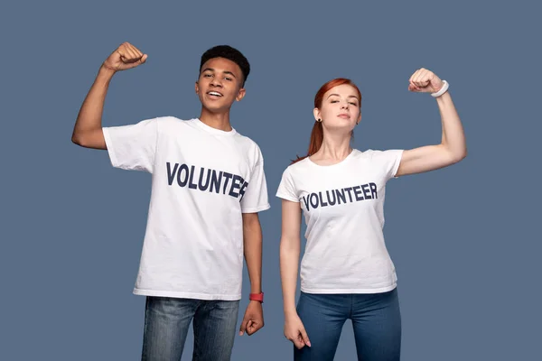 Pozitivní radostné dobrovolníci zvedl ruce — Stock fotografie