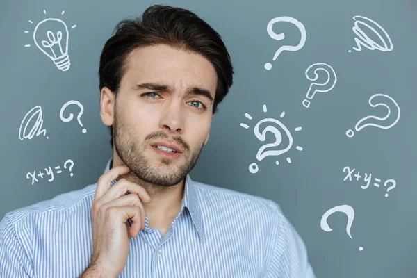 Frowning student scratching his beard and looking thoughtful — Stock Photo, Image