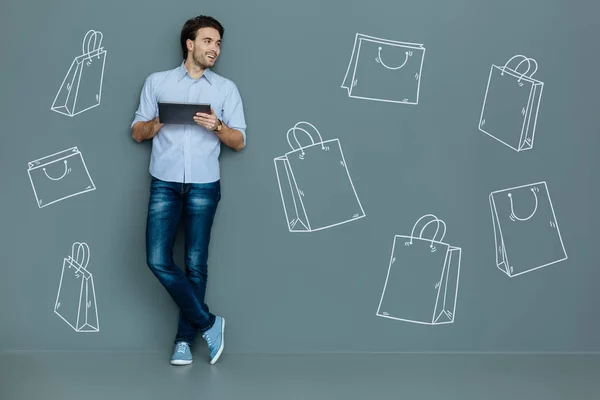 Uomo felice con un tablet sorridente mentre fa shopping online — Foto Stock