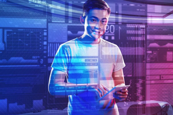 Young man looking happy while standing with a new modern device — Stock Photo, Image