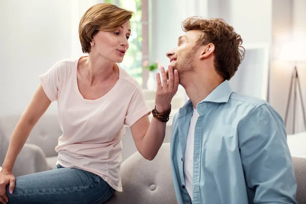 Mooie oudere vrouw aanraken van haar zonen chin — Stockfoto