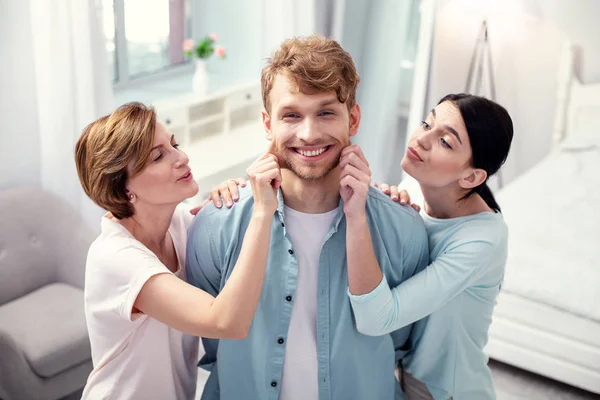 Encantado bom homem de pé entre sua mãe e esposa — Fotografia de Stock