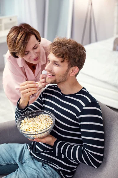Örömteli pozitív ember eszik pattogatott kukorica — Stock Fotó