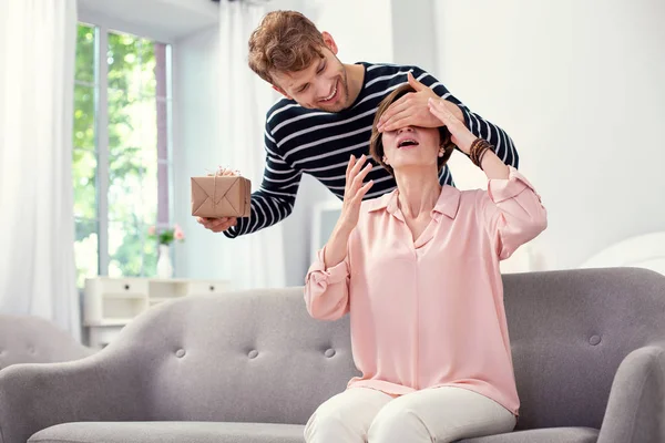 Buen hombre alegre cerrando los ojos de sus madres — Foto de Stock