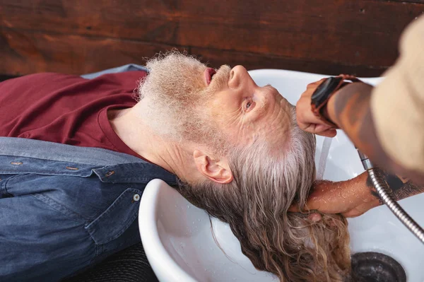 Homme aux cheveux gris sérieux visitant salon — Photo