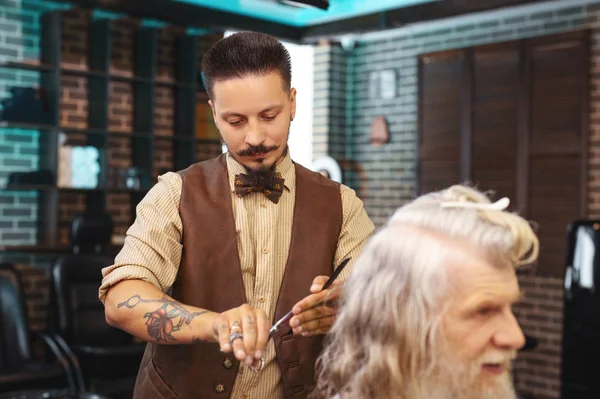 Attentive hairdresser working with pleasure — Stock Photo, Image