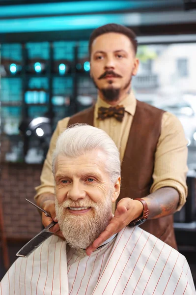 Professional barber doing his job with pleasure — Stock Photo, Image
