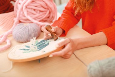 Creative woman stitching picture for decorating home clipart