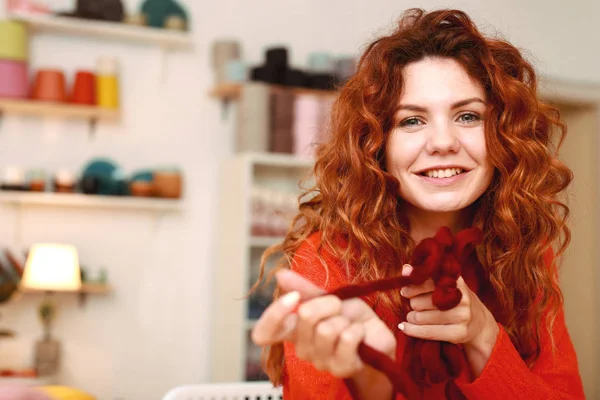 Привлекательная рыжеволосая девушка вязала бордовый свитер — стоковое фото