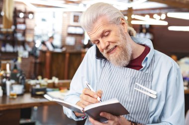 İşinin başında olacağına meşgul gri saçlı Kuaför