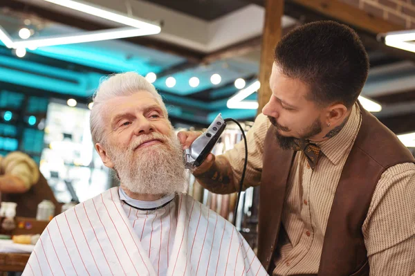 Pleased mature man enjoying his haircut