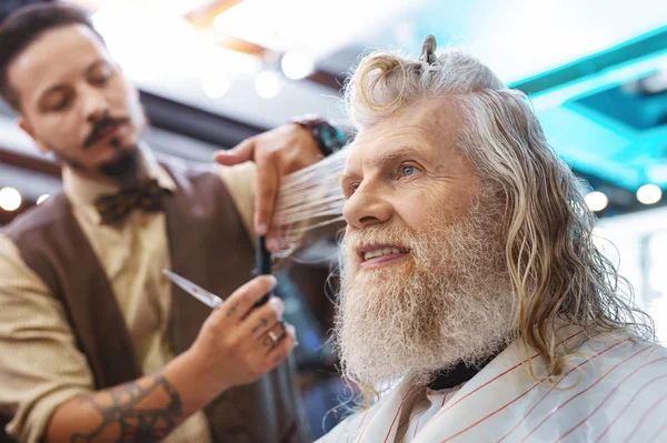 Positive delighted man sitting in barbershop — Stock Photo, Image