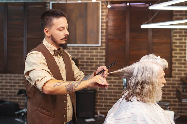 Серйозна брюнетка молодий чоловік ріже волосся — стокове фото