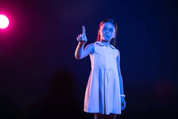 Dark-eyed girl pressing an imaginary button — Stock Photo, Image