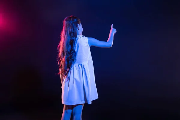 Long-haired schoolgirl pressing imaginary buttons — Stock Photo, Image