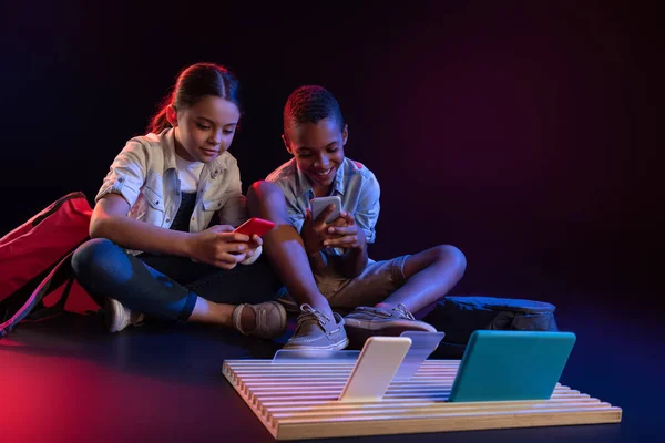 Happy children playing with their gadgets