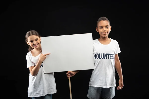 Oznámení dobrovolníci drží bílý stůl — Stock fotografie