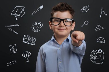 Neşeli çocuk genç işaret ve mutlu bir şekilde gülümseyerek