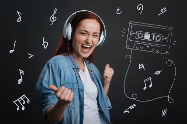 Kulaklıklar giyen ve onun yeni şarkı dinlerken heyecanlı müzisyen