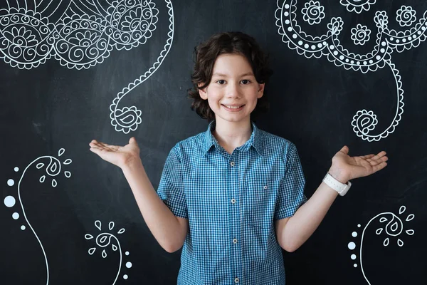 Ragazzo emotivo sorridente e mostrando belle piante — Foto Stock