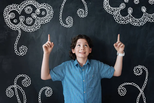 Clever boy looking up and pointing his fingers up — Stock Photo, Image