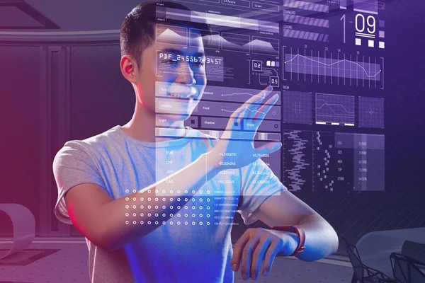 Heyecanlı genç adam akıllı saatini bir hologram oluşturmak için kullanma