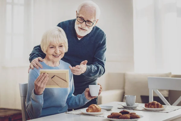 Happy aged man standing behind his wife — Stock Photo, Image