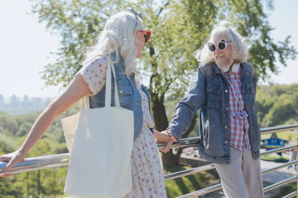 Pessoas idosas simpáticas em pé na ponte — Fotografia de Stock