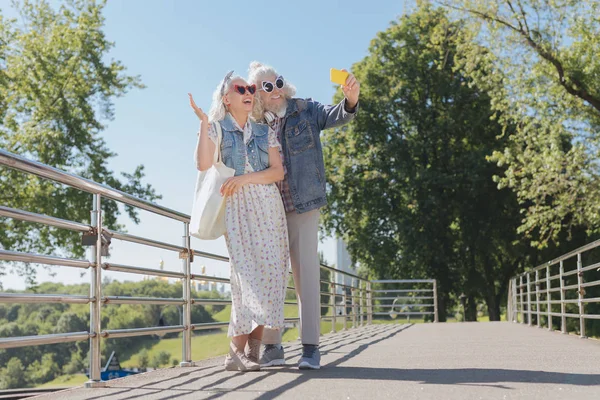 Feliz pareja agradable tomando fotos en el puente —  Fotos de Stock