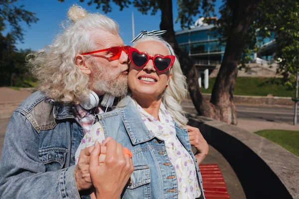 Гарний веселий чоловік цілує свою дружину в щоці — стокове фото