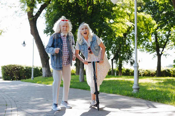 Gioiosa donna felice utilizzando uno scooter — Foto Stock