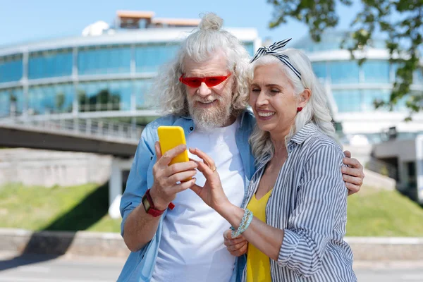 Pareja alegre positiva mirando la pantalla del teléfono inteligente —  Fotos de Stock