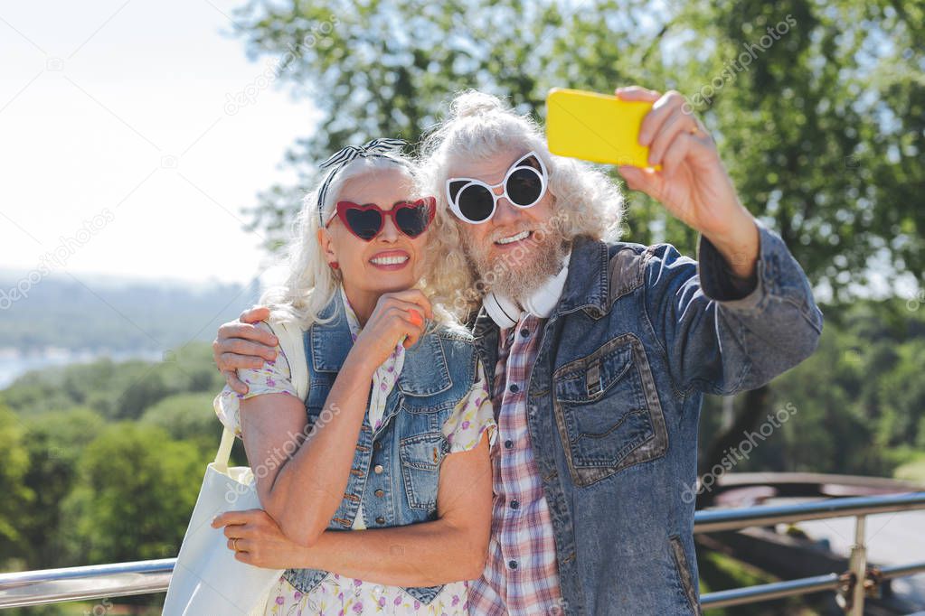 Delighted aged people wearing sunglasses