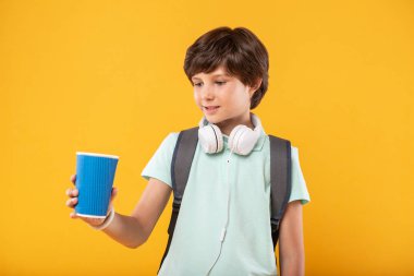 Bir fincan kahve tutan mutlu çocuk