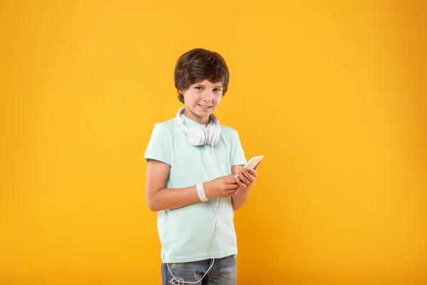 Ragazzo allegro utilizzando il suo telefono moderno — Foto Stock