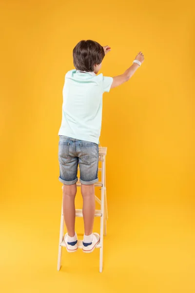 Niño feliz de pie en la escalera — Foto de Stock