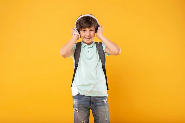 Alert schoolboy listening to music — Stock Photo, Image
