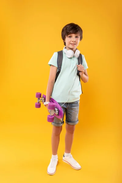 Uitbundige jongen houdt zijn skateboard — Stockfoto