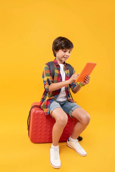 Χαρούμενη αγόρι κάθεται στις αποσκευές του — Φωτογραφία Αρχείου