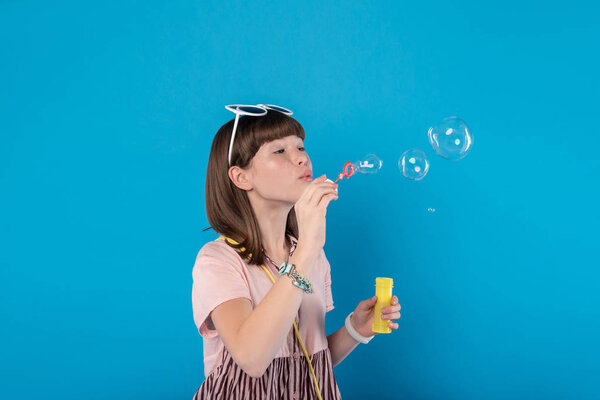 Content girl blowing soap bubbles