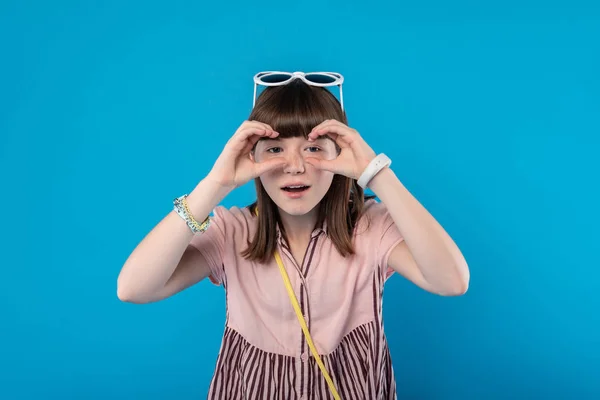 Content schoolgirl holding imaginary binocular — Stock Photo, Image