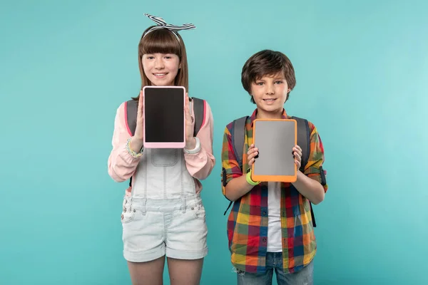 Niños felices mostrando sus tabletas —  Fotos de Stock