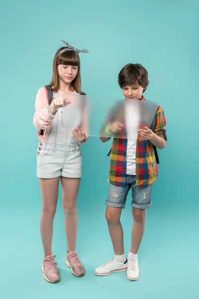 Niños escolares encantados sosteniendo una pantalla —  Fotos de Stock