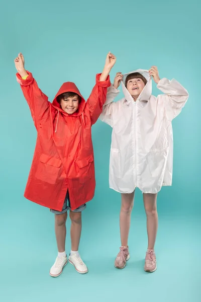 Uitbundige kinderen dragen mooie regenjassen — Stockfoto
