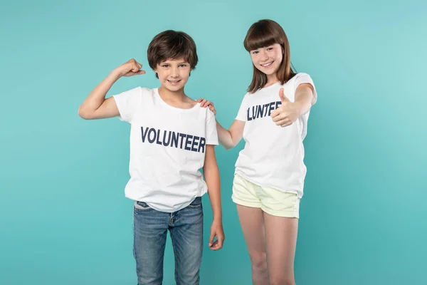 Voluntarios alegres mostrando sus músculos — Foto de Stock