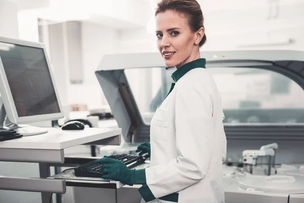 Cintura hacia arriba del trabajador de laboratorio satisfecho usando la computadora — Foto de Stock