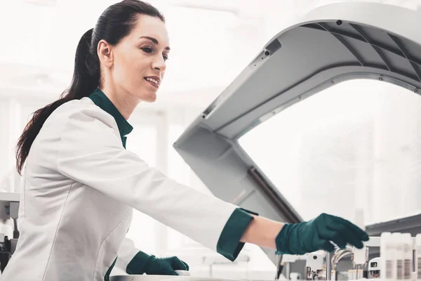 Cientista de laboratório satisfeito colocando tubos de ensaio em ordem — Fotografia de Stock