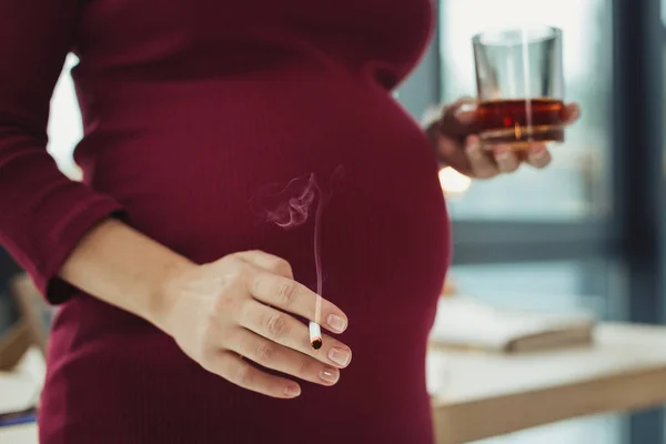 Безвідповідальна вагітна жінка палить і вживає алкоголь — стокове фото