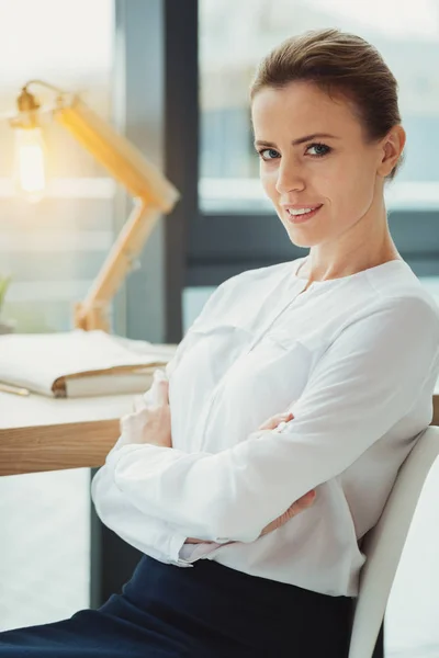 Smart affärskvinna sitter med armarna korsade medan att vara ensam — Stockfoto
