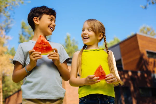 Vrolijke kinderen eten van een rijpe watermeloen — Stockfoto